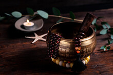 Close-up Of A Singing Bowl And Prayer Beads (mala) For Chanting Mantras As A Decoration On An Old Wooden Board