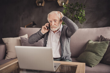 Canvas Print - Photo of impressed old man dressed white shirt sitting sofa looking modern device having call indoors flat home house