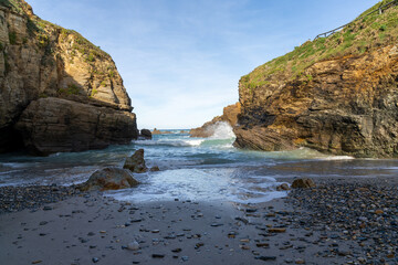 Poster - small rock and sand beach in a sheltered cove with cliffs on the side