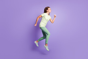 Poster - Full body profile portrait of attractive lady jumping running light green clothing isolated on purple color background