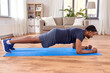 © Syda Productions - fitness, sport, training and concept - indian man doing plank exercise at home