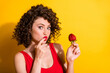© deagreez - Photo of cute pretty funny curly red lip lady girlfriend think idea plan surprise date hand strawberry finger lips wear tank top isolated vivid yellow color background