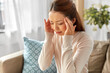 © Syda Productions - people and health concept - sick asian woman having headache at home