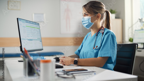 Latin American Doctor\'s Office: Experienced Head Nurse Wearing Face Mask Sitting at Her Desk Waiting for New Patient. Health Care Specialist Giving Advice. Patient not in Frame.