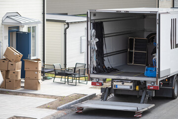 A moving truck is parked on the side of a building