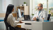 © Gorodenkoff - Hispanic Doctor Office: Female Patient Describes Her Symptoms to Friendly Physician. Medical Health Care Professional Giving Advice, Explaining Test Results, Prescribing Medicine.