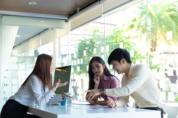 cropped shot of two ui developers meeting on their project with paperwork and tablet on meeting tabl