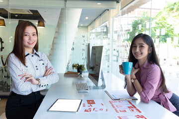 cropped shot of two ui developers meeting on their project with paperwork and tablet on meeting tabl