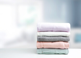 Wall Mural - Soft colors stack of clothing,clothes folded on table empty copy space background.Garment stacked.