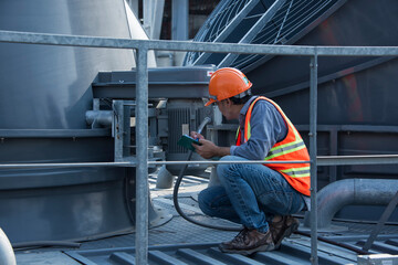 worker open valve of cooling tower on blue sky background. worker opening butterfly valve on top of cooling Tower. engineer check valve on cooling tower.