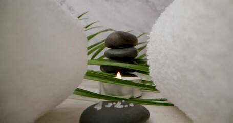 Wall Mural - spa and wellness - sliding through the white towels over massage stones