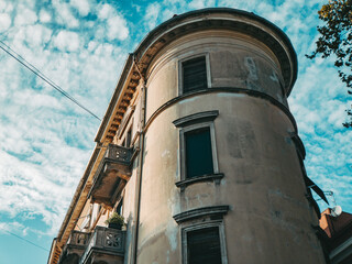 historic old rounded building with green wooden window shutters in the town with blue sky in the summer in croatia