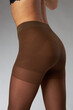 © monchak - advertising shooting of nylon tights on a model in the studio on a gray background, she is wearing brown tights