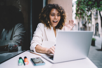 Shocked female freelancer with curly hair surprised with received web results via text email message on laptop computer, amazed IT professional respond emotionally to online news displayed on netbook