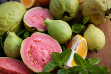 Wall Mural - sliced and whole guava and tangerine fruits with Basil leaves