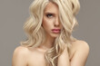 Beautiful girl with volume wavy long hair blonde has a natural hairstyle of wavy curly