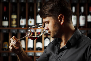 Wall Mural - Bokal of red wine on background, male sommelier appreciating drink