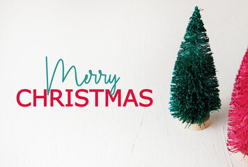Canvas Print - Horizontal Merry Christmas text with green and pink bottle brush holiday trees, decorations isolated on white background.