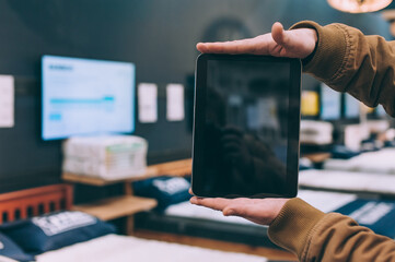 Wall Mural - A man in a furniture store holds a tablet in his hand.