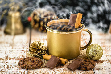 hot chocolate in golden copper mug, hot Christmas or winter drink with cinnamon, smoke or steam.