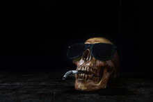 Close-up Of Human Skull With Cigarette Against Black Background