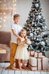 Wall Mural - children in the new year's interior at the Christmas tree, playing, waiting for the new year, gifts, holiday, happiness