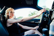 © dmitriisimakov - Beautiful blonde woman behind the wheel of car rides
