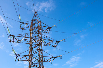 Transmission tower and power lines against blue sky