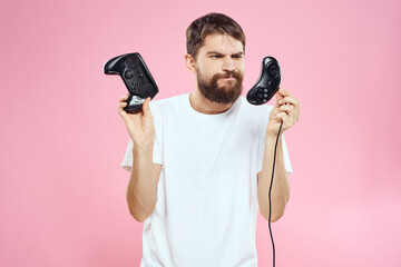 Wall Mural - Man with two joysticks in hands fun game technology lifestyle pink background