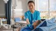 © Gorodenkoff - Hospital Ward: Friendly Chinese Head Nurse Adjusts Nasal Cannula to a Sick Male Patient Resting in Bed According Treatment Plan. Nurse Helps Man Getting well after Serious Surgery.