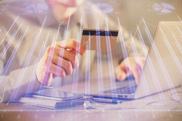 Double exposure of man hands holding a credit card and Forex graph drawing. Stock trading and digital fintech in Internet E-commerce concept.