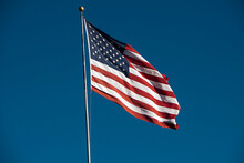 Low Angle View Of American Flag Against Clear Blue Sky