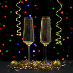 Christmas card with two glasses of sparkling wine on the background of bokeh.