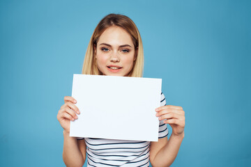 Canvas Print - Woman holding sheet of paper striped T-shirt Copy Space cropped view blue background