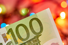 A Part Of 100 Euro Bill Against A Background Of Colorful Lights. Close-up, Selective Focus