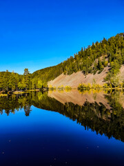 reflection of the sky and trees in blue
lake - Strømsdammen