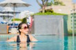 © siraphol - Portrait beautiful young asian woman relax smile around outdoor swimming pool