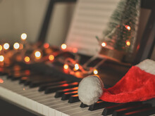Christmas  Santa Claus Hat On Electric Piano Keyboard With Christmas Lights Decoration  Background. Christmas Party Music Concept.selective Focus