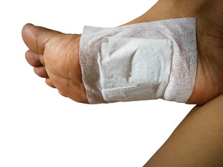 the feet of people suffering from bruises. apply a thai herbal pain relief patch on the soles of the