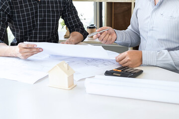 Wall Mural - Team of engineering or architect meeting and discussing on blueprint and building model while checking information on sketching for architectural project