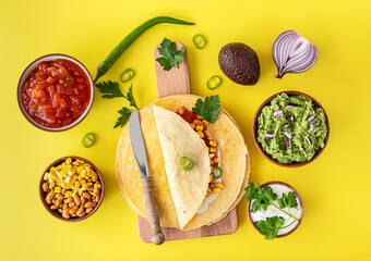 Tortilla wrap or burrito with corn, beans, greens, and homemade guacamole.