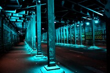 Empty Illuminated Street By Pillars At Night