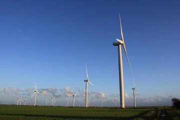 Wind farm turbines that produce electricity energy. Windmill Wind power technology productions Wind turbines standing in green field - stock footage