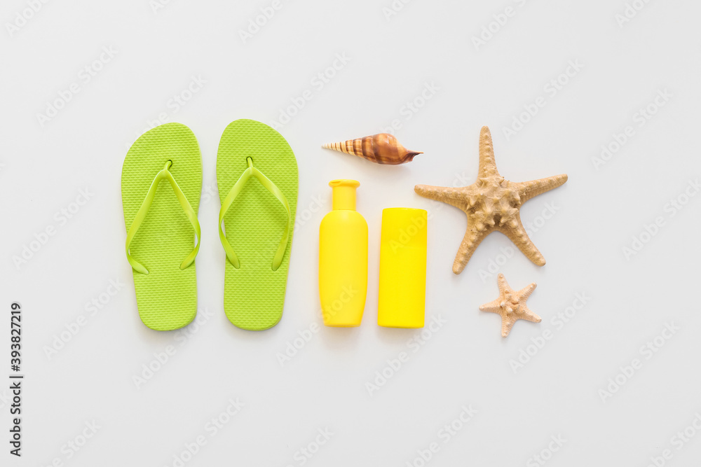 Set of beach accessories with flip-flops on white background