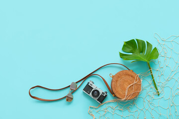 Set of beach accessories with photo camera on color background