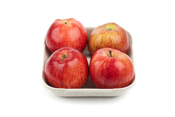 Wall Mural - Four fresh red apples in a pulp paper tray. Studio photo isolated on white.