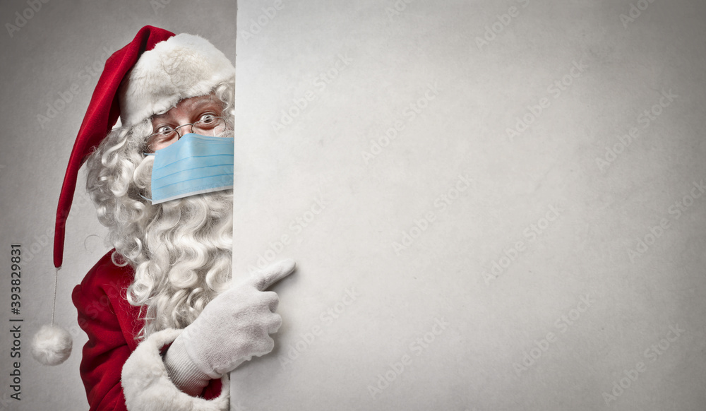 Santa Claus with mask points on a white billboard - obrazy, fototapety, plakaty 