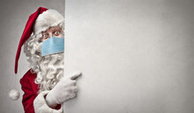 Santa Claus With Mask Points On A White Billboard