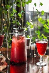 Wall Mural - fresh fruit red punch lemonade jug and glass on wooden table at restaurant