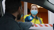 © TommyStockProject - Woman worker in mask at border entry point checking temperature of male driver in car